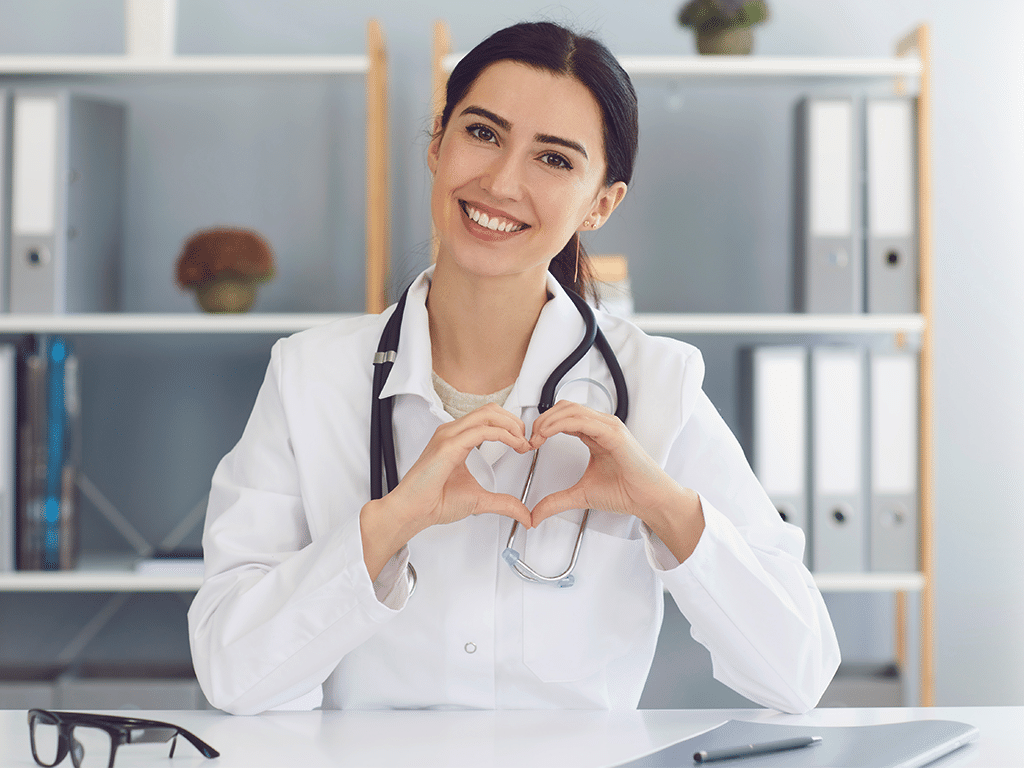 Female Doctor Showing Heart Gesture Indoors. Cardiologist mobile